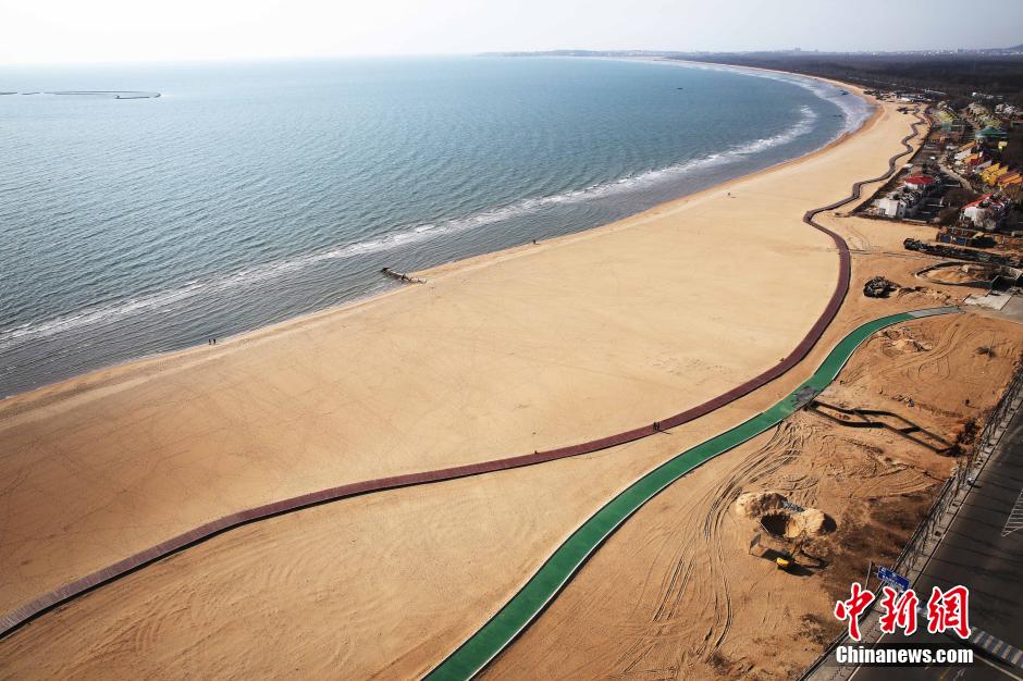 3月13日，秦皇島萬米臨海沙灘木棧道。據(jù)了解，該木棧道全長(zhǎng)約4200米，與北戴河區(qū)原有的7500米木棧道對(duì)接后全線總長(zhǎng)度1.17萬米，整個(gè)木棧道東起秦皇島體育基地游船碼頭，西至北戴河濕地公園，呈波浪形蜿蜒10.4公里海岸線。 中新社發(fā) 曹建雄 攝 CNSPHOTO